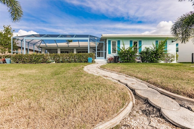 back of house featuring stucco siding, a lawn, and a lanai