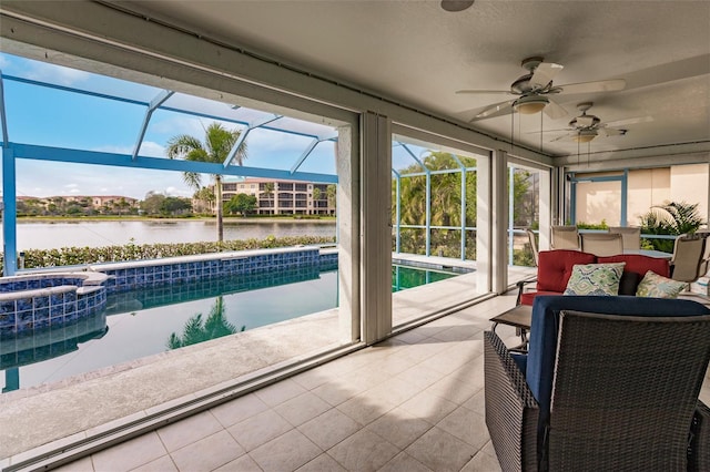 sunroom / solarium with ceiling fan and a water view