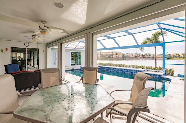 exterior space with a swimming pool, a ceiling fan, and a water view