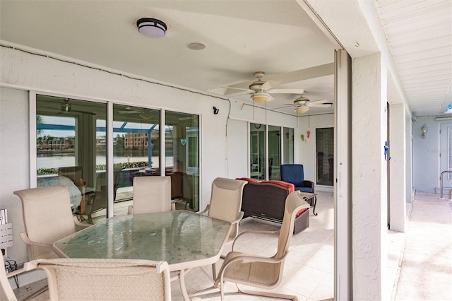 view of patio / terrace with outdoor dining space, ceiling fan, and a water view