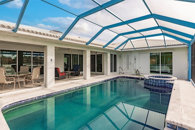 view of swimming pool with glass enclosure, a patio, a pool with connected hot tub, and ceiling fan