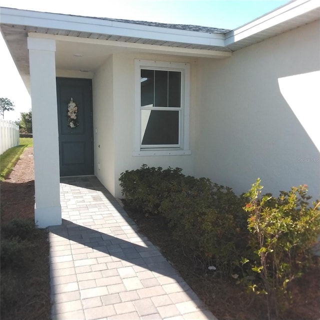 view of exterior entry featuring stucco siding