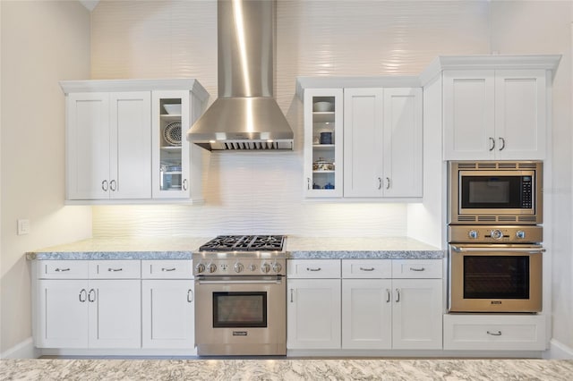 kitchen with white cabinets, wall chimney exhaust hood, backsplash, and stainless steel appliances