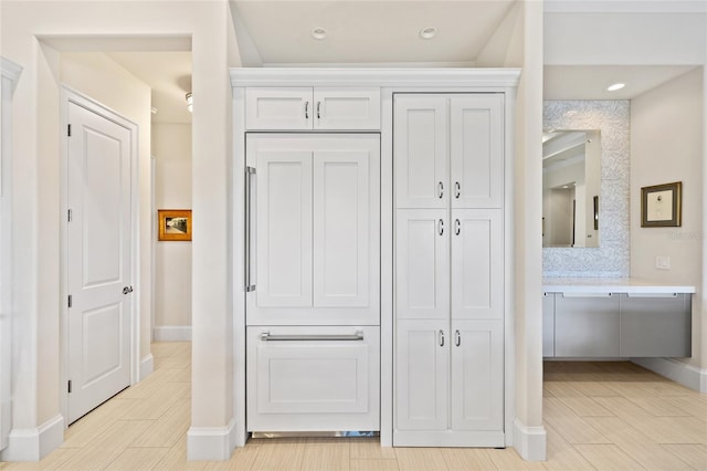 hall featuring wood finish floors, recessed lighting, and baseboards
