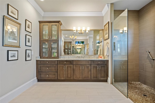 bathroom with a chandelier, a tile shower, vanity, and ornamental molding