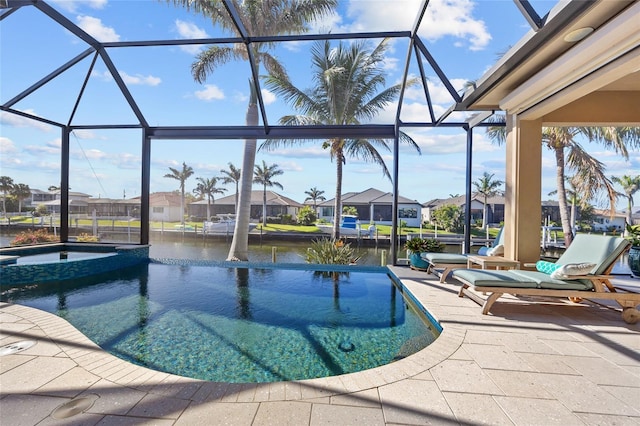 view of swimming pool with a pool with connected hot tub, a water view, a residential view, glass enclosure, and a patio
