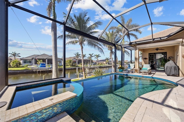 view of pool featuring a water view, a patio, a lanai, and a pool with connected hot tub