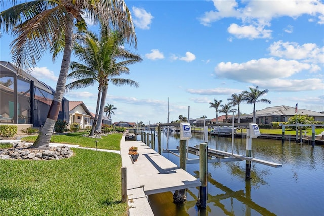 dock area featuring a water view, a residential view, glass enclosure, a yard, and boat lift
