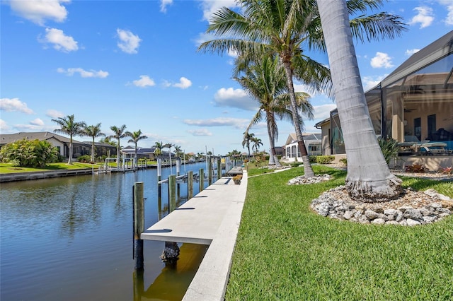 view of dock with a water view, a residential view, glass enclosure, a yard, and boat lift