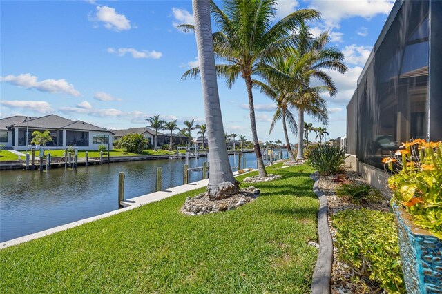 view of yard featuring a residential view, glass enclosure, a boat dock, and a water view