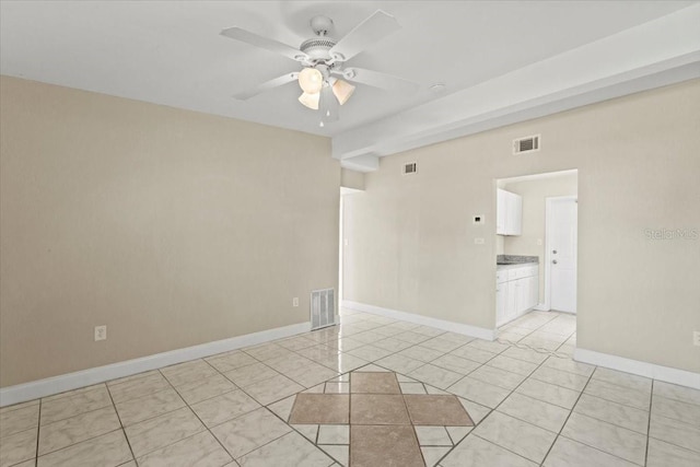 empty room featuring light tile patterned floors, visible vents, and ceiling fan