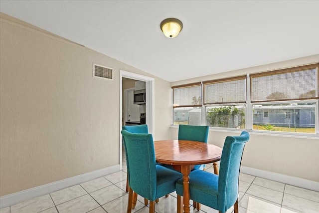 dining room featuring light tile patterned floors, baseboards, and visible vents