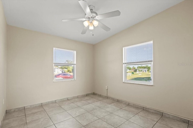 spare room with light tile patterned floors, baseboards, and ceiling fan