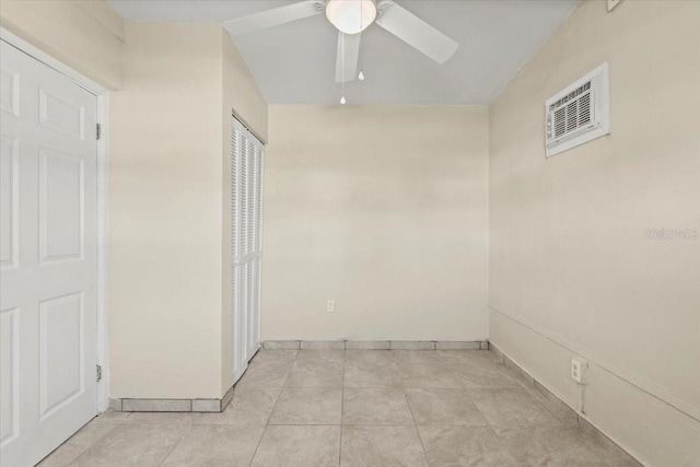 empty room with light tile patterned floors, a ceiling fan, and visible vents