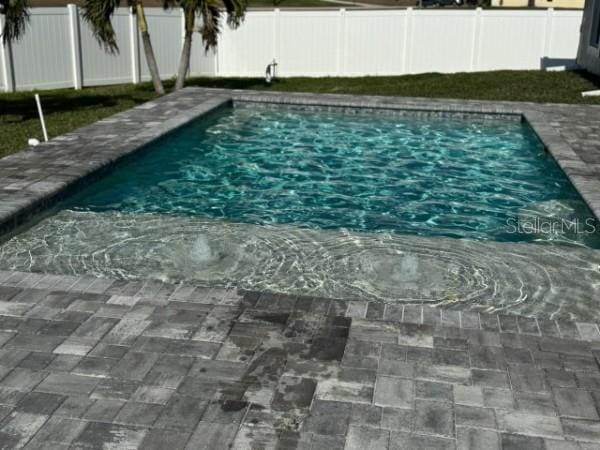 view of swimming pool featuring a fenced in pool, a patio, and a fenced backyard