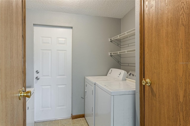 laundry room featuring a textured ceiling, washing machine and dryer, and laundry area