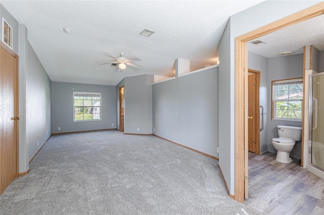 unfurnished bedroom featuring multiple windows, visible vents, and a textured ceiling