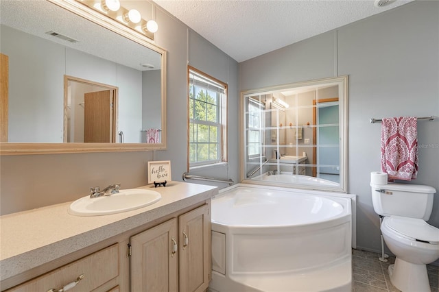 bathroom featuring visible vents, toilet, a textured ceiling, a bath, and vanity