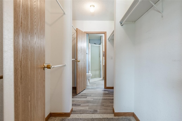 hallway featuring a textured ceiling and baseboards