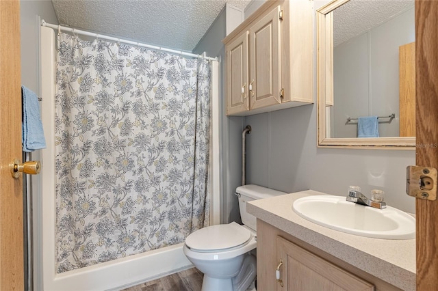 bathroom with vanity, toilet, a shower with curtain, and a textured ceiling