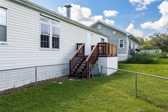 back of house with a lawn, fence, stairway, a wooden deck, and a chimney