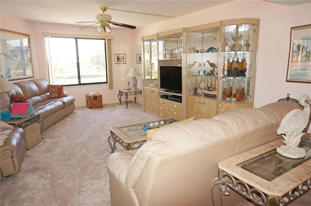 living area with baseboards, light colored carpet, and ceiling fan