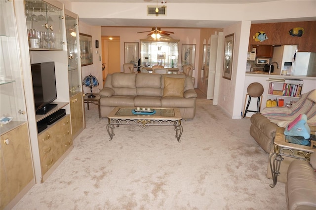 living area featuring visible vents, carpet floors, and ceiling fan