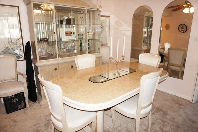 carpeted dining room with baseboards and ceiling fan