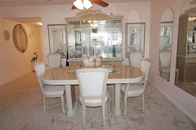 dining space with tile patterned flooring, a ceiling fan, and baseboards