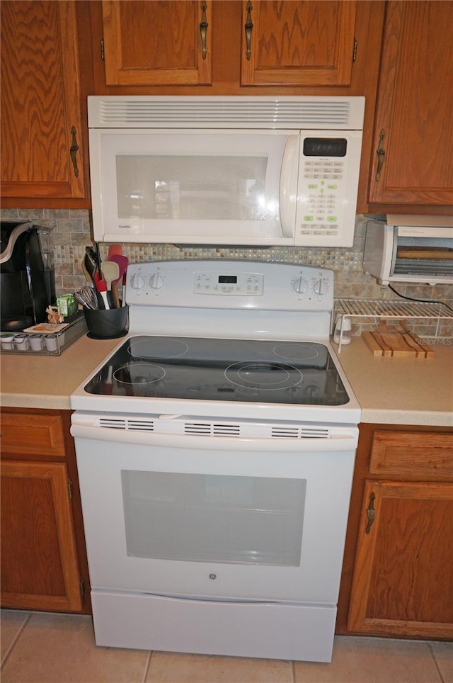 kitchen with white appliances, brown cabinets, and light countertops