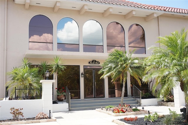 entrance to property featuring stucco siding and a tile roof