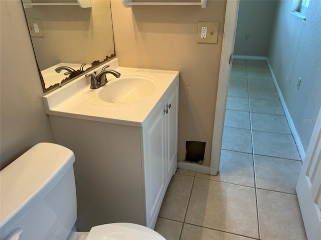 bathroom featuring vanity, tile patterned floors, toilet, and baseboards