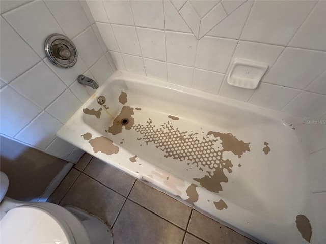 bathroom featuring a washtub, toilet, and walk in shower