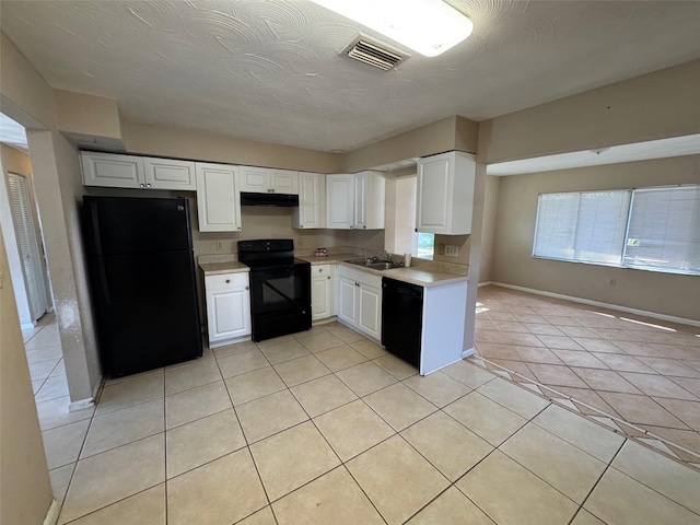 kitchen featuring visible vents, under cabinet range hood, light countertops, black appliances, and a sink