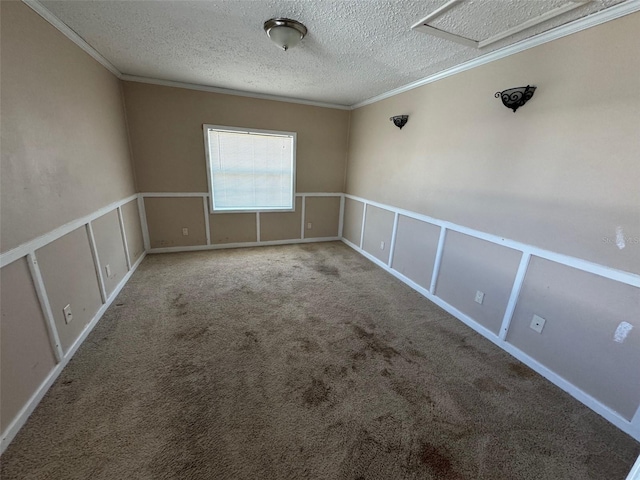 carpeted spare room with a wainscoted wall, a textured ceiling, crown molding, and a decorative wall