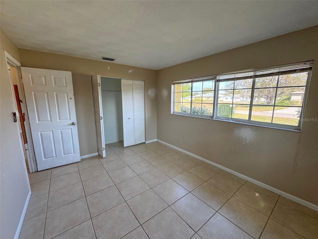30147 Holly Rd, Punta Gorda, FL 33982 - unfurnished bedroom featuring baseboards, visible vents, a closet, and light tile patterned floors