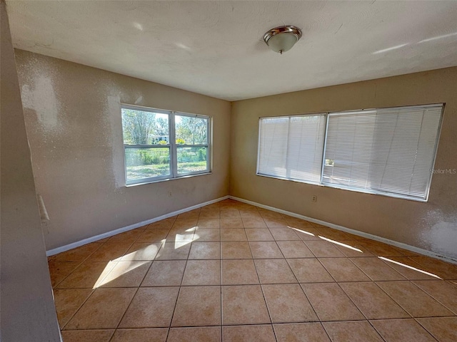 30147 Holly Rd, Punta Gorda, FL 33982 - unfurnished room with light tile patterned flooring, a textured wall, and baseboards