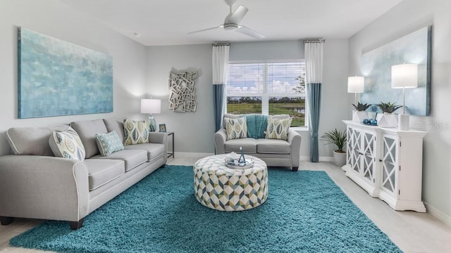 living area featuring baseboards and a ceiling fan