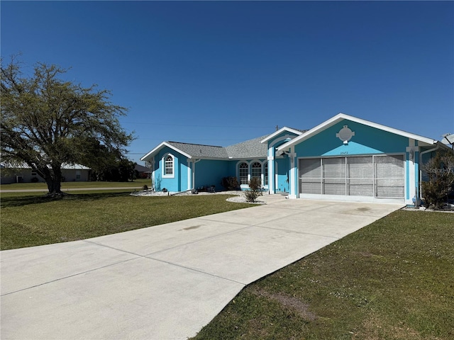 single story home featuring a garage, driveway, a front yard, and stucco siding