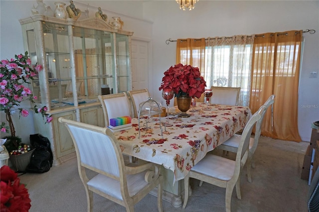 dining room featuring a notable chandelier and light colored carpet