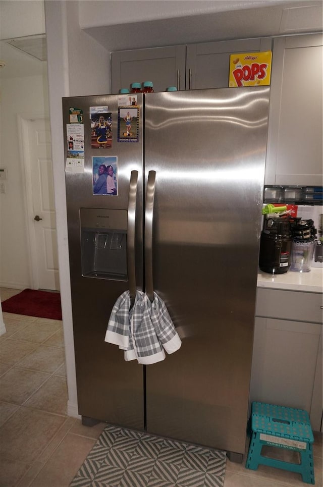 details with gray cabinets, light countertops, and stainless steel refrigerator with ice dispenser