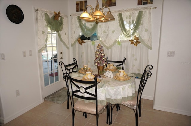 tiled dining space with an inviting chandelier and baseboards