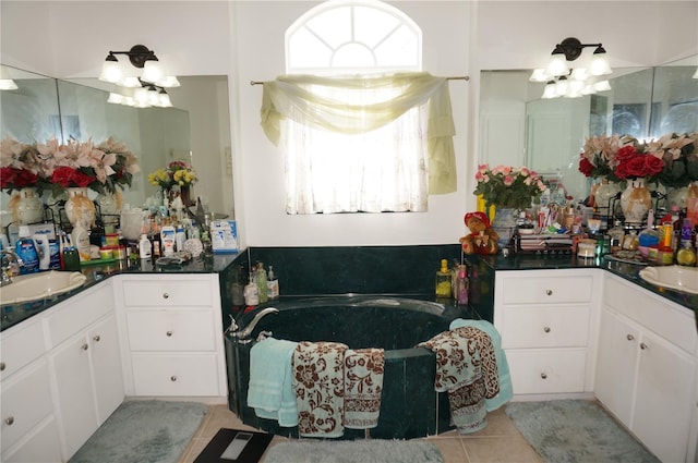 bathroom featuring a sink, an inviting chandelier, a bath, and tile patterned flooring