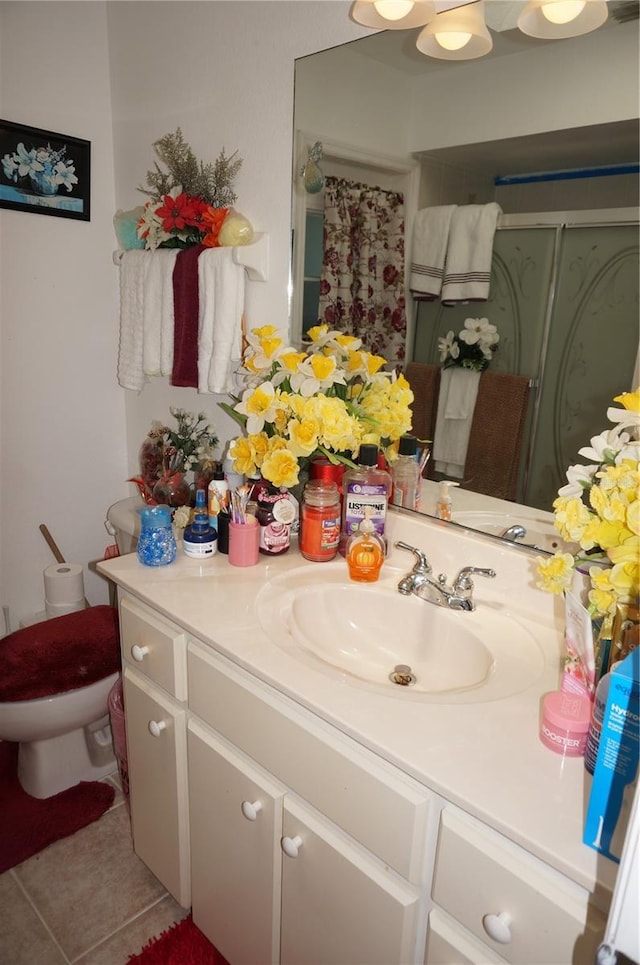 full bathroom featuring tile patterned flooring, a shower stall, vanity, and toilet