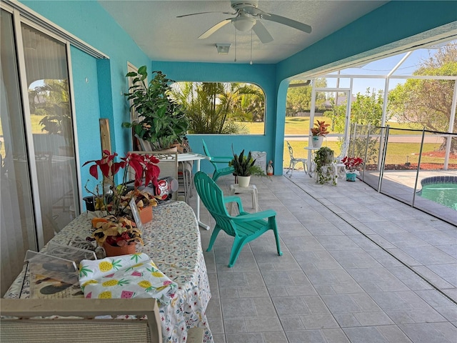 unfurnished sunroom featuring ceiling fan