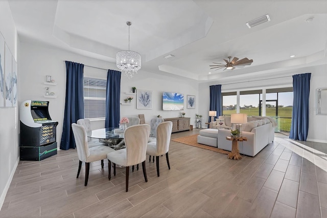 14381 Heritage Landing Blvd, Punta Gorda, FL 33955 - dining space featuring wood finish floors, ceiling fan with notable chandelier, and a tray ceiling