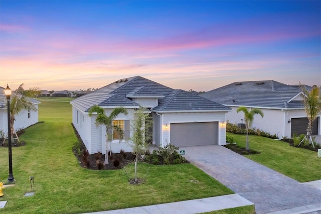 14381 Heritage Landing Blvd, Punta Gorda, FL 33955 - ranch-style house featuring a tiled roof, an attached garage, a yard, and driveway