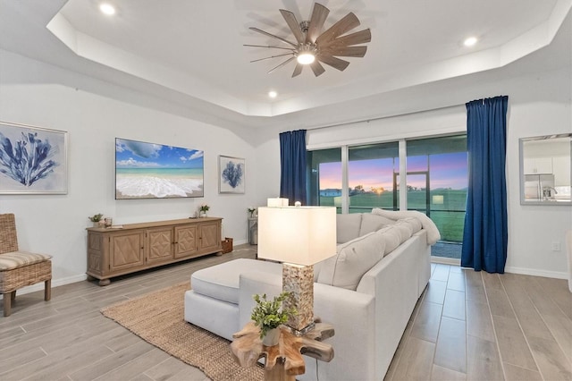 14381 Heritage Landing Blvd, Punta Gorda, FL 33955 - living area featuring a tray ceiling, baseboards, ceiling fan, and wood tiled floor