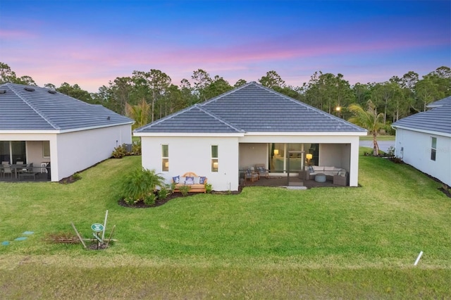 14381 Heritage Landing Blvd, Punta Gorda, FL 33955 - back of property featuring a tile roof, a lawn, stucco siding, outdoor lounge area, and a patio area