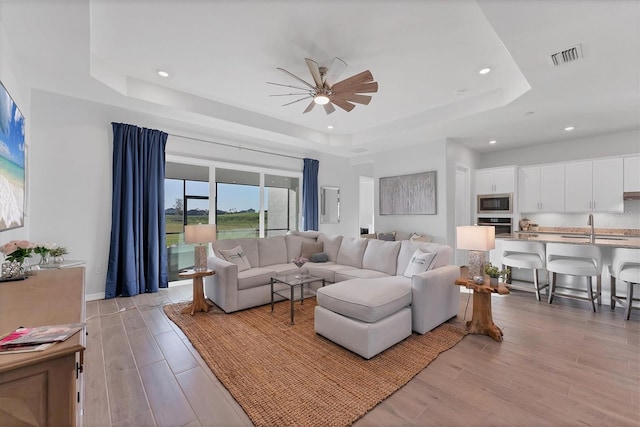 14381 Heritage Landing Blvd, Punta Gorda, FL 33955 - living area featuring visible vents, recessed lighting, light wood-style flooring, a raised ceiling, and a ceiling fan
